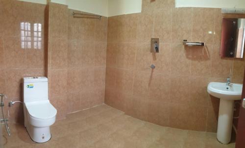 a bathroom with a toilet and a sink at London House Resort in Birātnagar