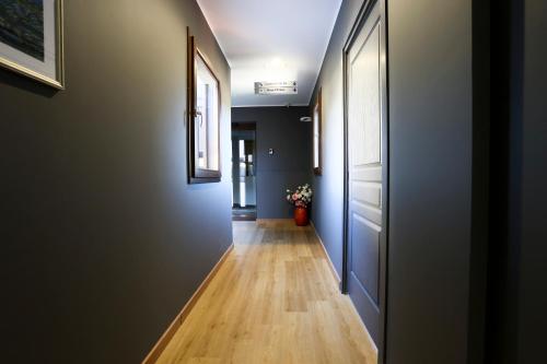 a hallway with blue walls and a wooden floor at La Piana Hotel in Tito