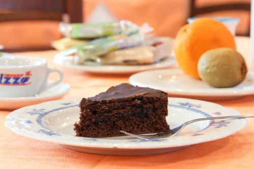 a piece of chocolate cake on a plate with a fork at La Piana Hotel in Tito