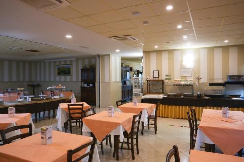 a restaurant with tables and chairs and a kitchen at La Piana Hotel in Tito