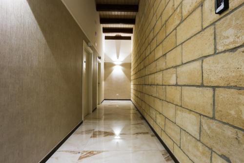 an empty hallway with a brick wall and a light at La Piana Hotel in Tito