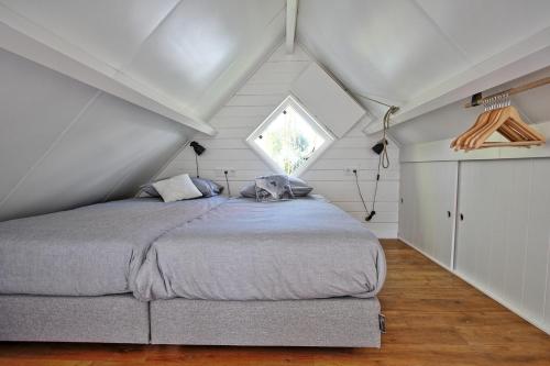 een slaapkamer met een bed op zolder bij Vakantiehuisje Lijsterhofstraat 13 - Baddomburg in Domburg