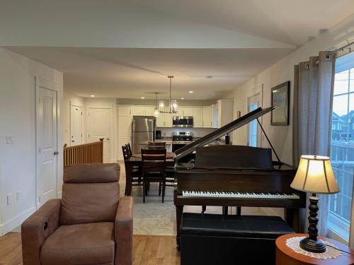 a living room with a piano and a dining room at By The Bay Stratford The Romeo Home in Stratford