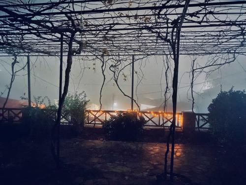 a view of a building with lights in a foggy yard at St. John Traditional House in Áyios Ioánnis