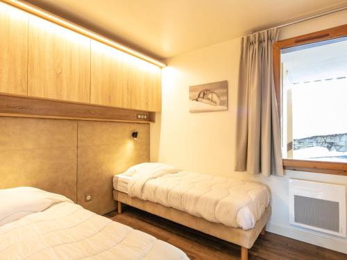 a bedroom with two beds and a window at Vacancéole - Résidence Le Beauregard in La Léchère