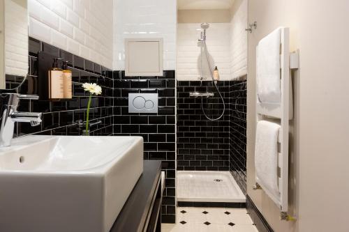 La salle de bains en noir et blanc est pourvue d'un lavabo et d'une baignoire. dans l'établissement Ours Blanc Hotel & Spa, aux Menuires