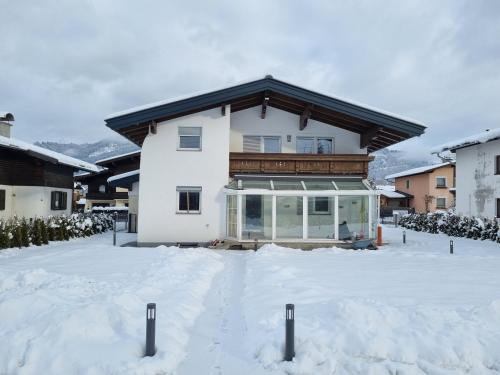 a house with snow in front of it at Spa Chalet by we rent in Zell am See