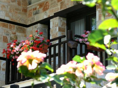 a balcony with flowers on a brick building at Petrini Gonia in Livadero
