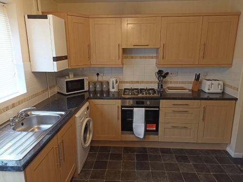 a kitchen with a sink and a stove top oven at Comfortable Billericay Home in Billericay