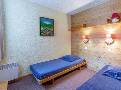 a bedroom with two beds and a wooden wall at Appartement Valmorel, 2 pièces, 5 personnes - FR-1-356-201 in Valmorel
