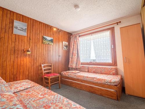 a bedroom with a window and a bed and a chair at Appartement Valmorel, 1 pièce, 4 personnes - FR-1-356-291 in Valmorel