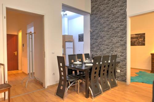 uma sala de jantar com uma mesa preta e cadeiras em Central Capital Apartments em Budapeste