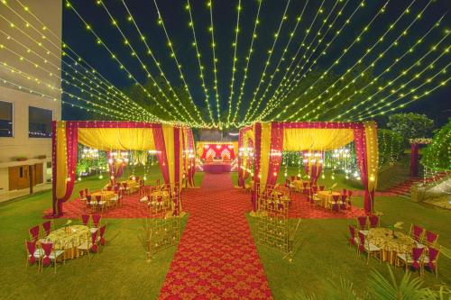 a banquet hall with tables and chairs and lights at Lemon Tree Hotel Baddi in Baddi