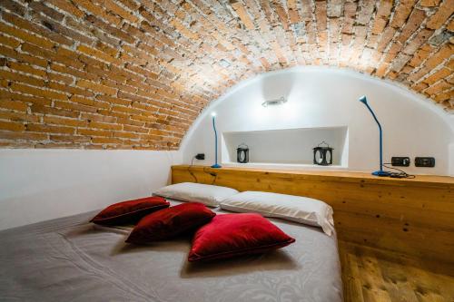 two beds in a room with a brick wall at FEEL - Sweet Old Town in Bergamo