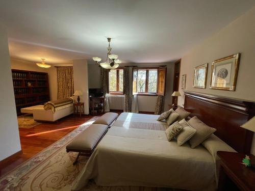 a large bedroom with a large bed and a living room at Casa rural en entorno privilegiado 