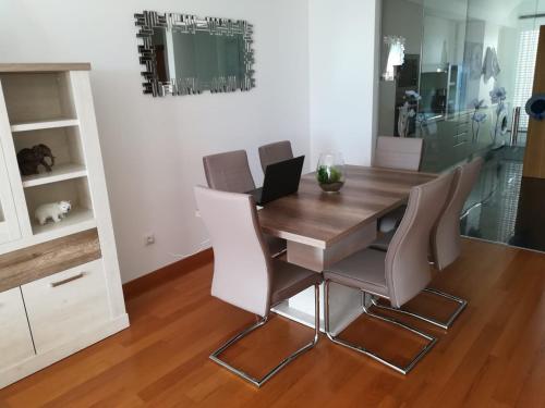 uma sala de jantar com uma mesa de madeira e cadeiras em Tamariz Flat em Santa Cruz - Madeira