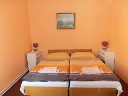 a small bedroom with two beds and two night stands at Penzion u České Koruny in Jičín