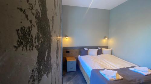 - une chambre avec un lit et un mur orné de peinture dans l'établissement Бутик отель AVENUE, à Nalchik