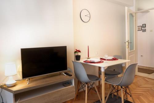 a living room with a television and a table with chairs at Apartment Igor in Lukavica