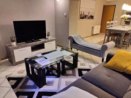 a living room with a couch and a tv at 3 Bedroom apartment in the Center of Larochette in Larochette
