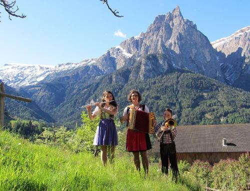 a group of people playing instruments in the mountains at Schildberghof Panorama in Siusi
