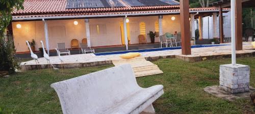 a white bench in front of a house at Nosso Recanto Pérola in Capitólio