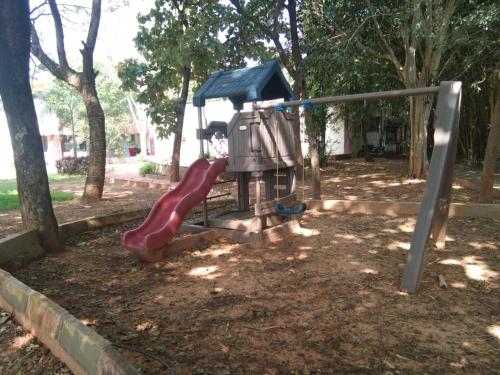 a playground with a red slide in a park at KSTDC Hotel Mayura Pavithra Yediyur in Kunigal