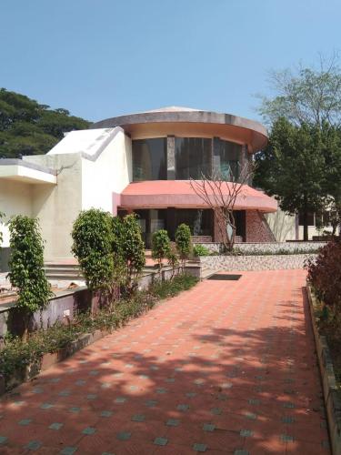 a building with a red brick walkway in front of a building at KSTDC Hotel Mayura Pavithra Yediyur in Kunigal