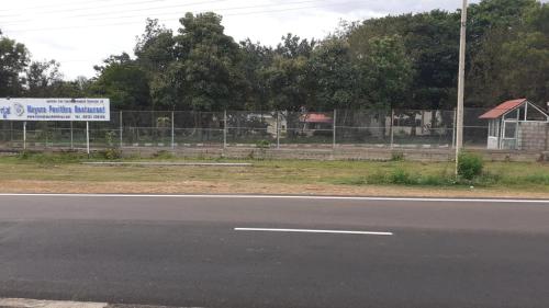 a sign on the side of a road next to a fence at KSTDC Hotel Mayura Pavithra Yediyur in Kunigal