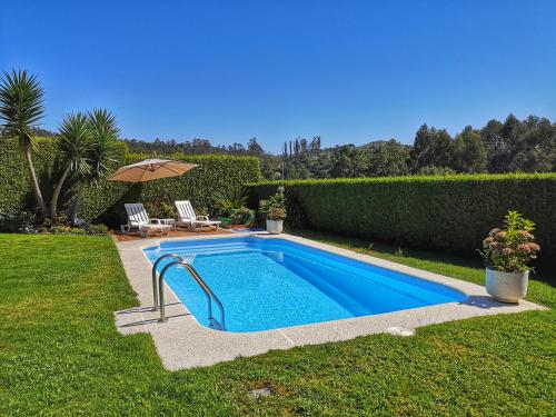 einen Pool im Garten mit Sonnenschirm in der Unterkunft Hogar Gallán in Gondomar