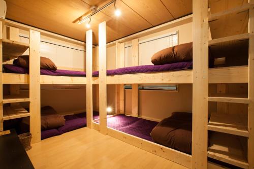 Habitación con 2 literas y mantas moradas. en Guest House Shinagawa-shuku en Tokio