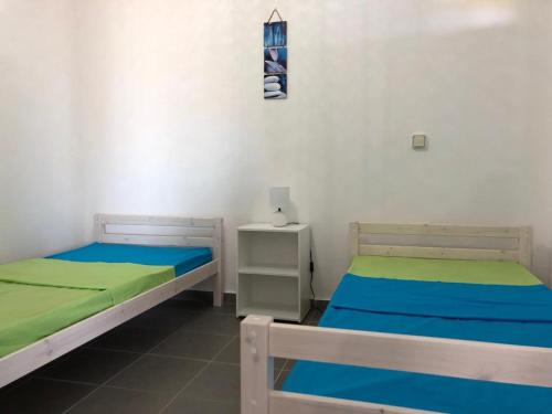 ein Zimmer mit 2 Betten und einem Nachttisch in einem Zimmer in der Unterkunft 3soleils in Schœlcher