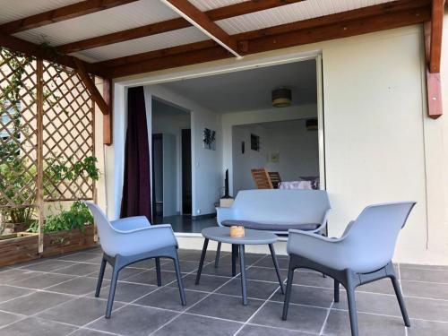 un patio con sillas, una mesa y un sofá en 3soleils, en Schœlcher