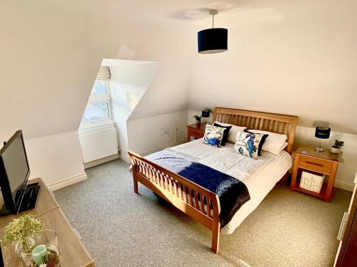 a bedroom with a bed and a large window at Penthouse Apartment, Moments from Beach and Town, On Site Parking, Fast WIFI, Sleeps up to 6, Rated Exceptional in Swanage