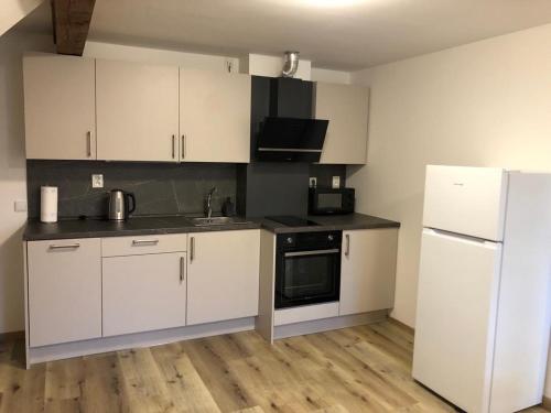 cocina con armarios blancos y nevera blanca en Apartmány Rudník Bolkov, en Rudník