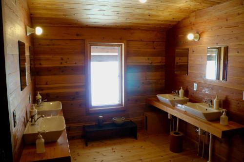 妙高的住宿－björk （森の宿 ビヨルク），一间带三个盥洗盆和窗户的浴室