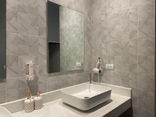 a bathroom with a white sink and a mirror at Rock Forest in Sattahip
