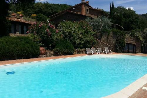 una piscina con due sedie e una casa di Villa Pianelli ad Arezzo