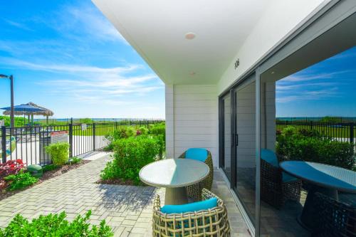 a patio with a table and chairs on a balcony at Anna Maria Beach Resort in Holmes Beach