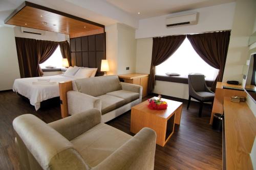a hotel room with a bed and a living room at C'haya Hotel in Kota Kinabalu
