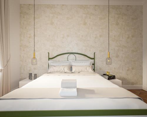 a bedroom with a large white bed with two lights at Vila Perast Boutique Hotel in Perast