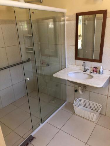 a bathroom with a glass shower and a sink at POUSADA BLUE MOON in Búzios