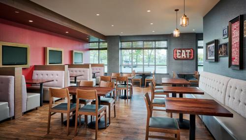 a restaurant with wooden tables and chairs and a bar at Holiday Inn & Suites Oakville at Bronte by IHG in Oakville