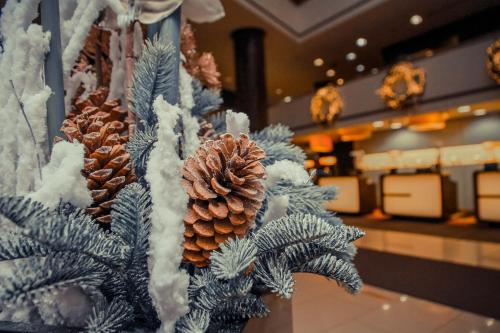 uma árvore de Natal com pinhas numa loja em AZIMUT Hotel Olympic Moscow em Moscovo