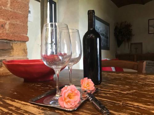 a bottle of wine and two wine glasses on a table at Il Fiorino di Badia in Badia A Passignano