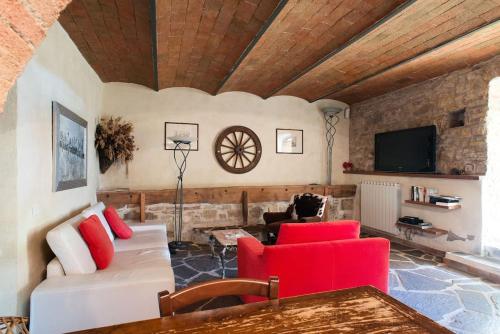 a living room with a white couch and red chairs at Il Fiorino di Badia in Badia A Passignano