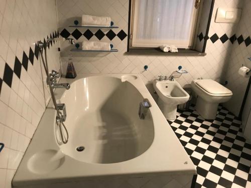 a bathroom with a white tub and a toilet at Gatto Bianco Bergamo 9 in Bergamo