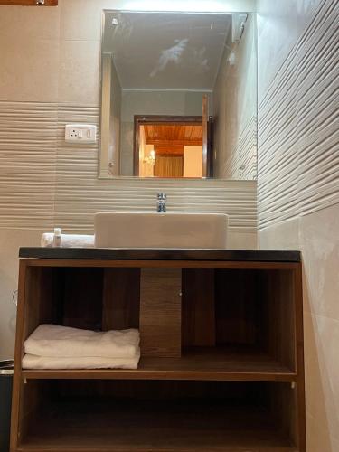 a bathroom with a sink and a mirror at The Edgeworth in Shimla