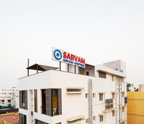 a building with a sign on top of it at Sarvam Serviced Apartment in Coimbatore