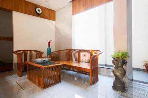a living room with two chairs and a table at Sarvam Serviced Apartment in Coimbatore
